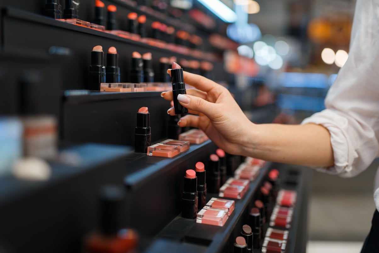 Woman Takes Lipstick from Shelf in Cosmetics Store